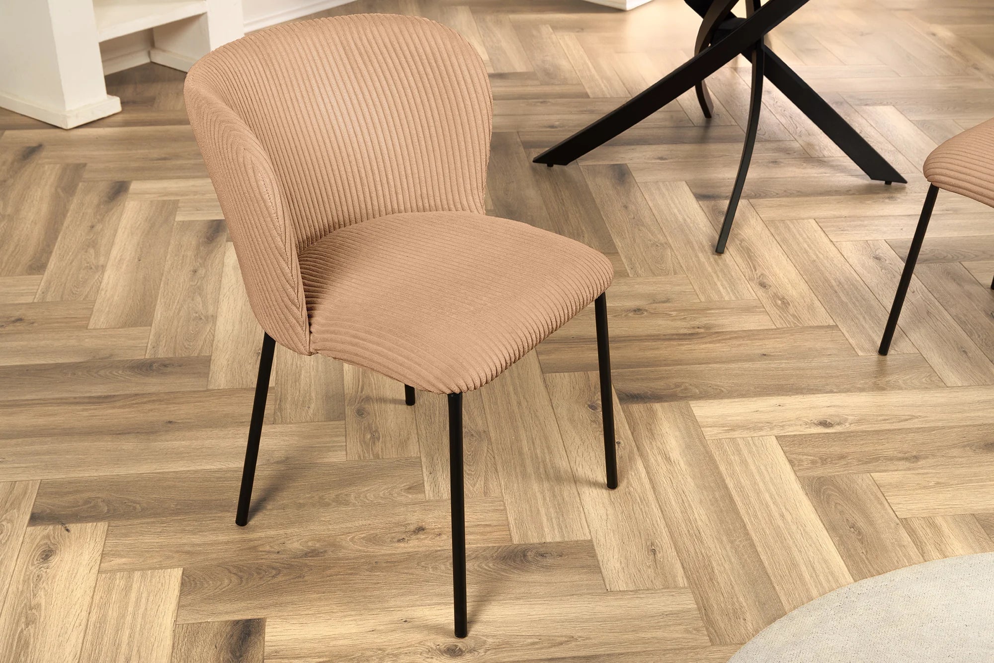 Nowoczesne krzesło z tapicerką ze sztruksu o prążkowanej fakturze i czarnymi nogami z metalu – elegancki dodatek do jadalni lub salonu