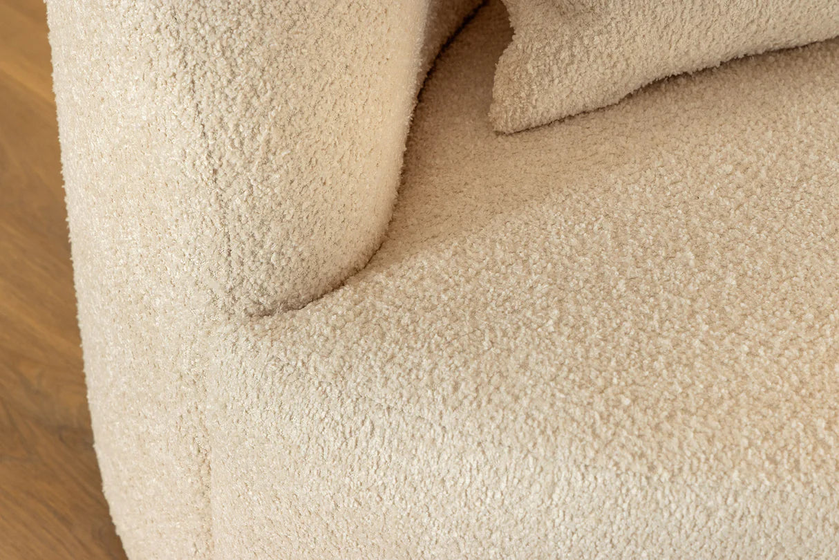 Beżowa sofa z tkaniny bouclé o opływowym kształcie – nowoczesny mebel wypoczynkowy do eleganckiego salonu