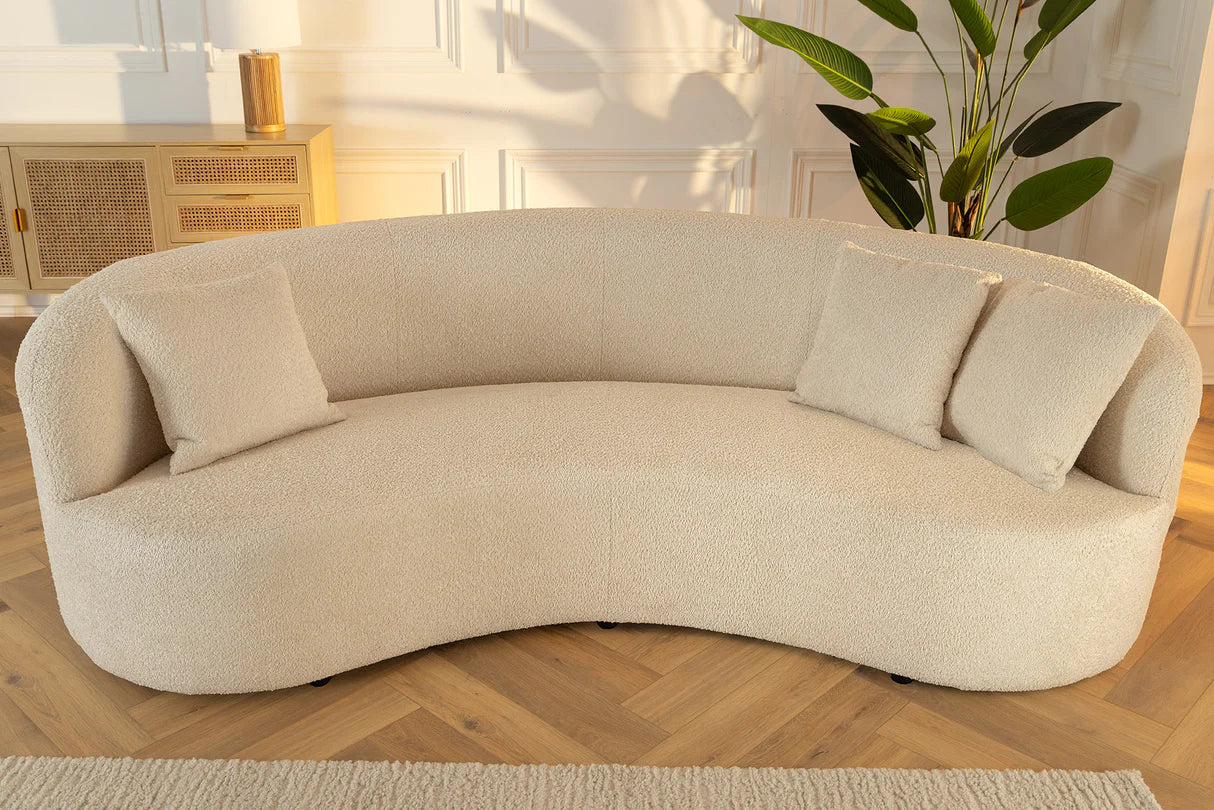 Beżowa sofa z tkaniny bouclé o opływowym kształcie – nowoczesny mebel wypoczynkowy do eleganckiego salonu