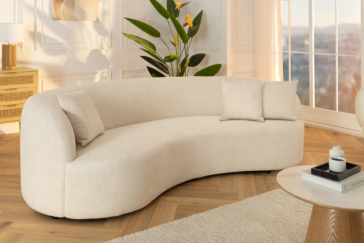 Beżowa sofa z tkaniny bouclé o opływowym kształcie – nowoczesny mebel wypoczynkowy do eleganckiego salonu