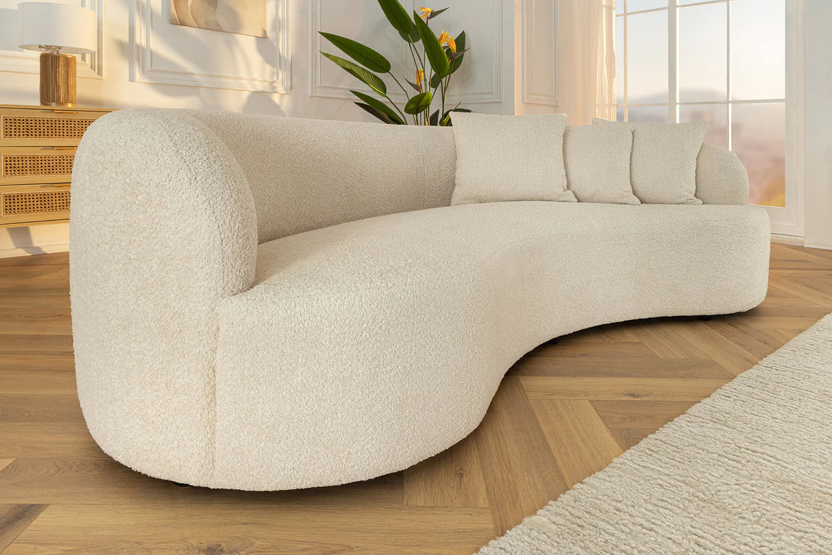 Beżowa sofa z tkaniny bouclé o opływowym kształcie – nowoczesny mebel wypoczynkowy do eleganckiego salonu