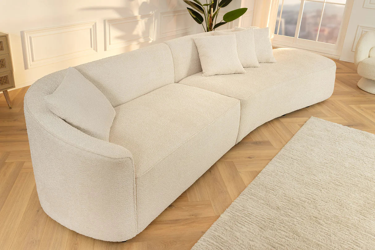 Beżowa sofa z tkaniny bouclé o opływowym kształcie – nowoczesny mebel wypoczynkowy do eleganckiego salonu