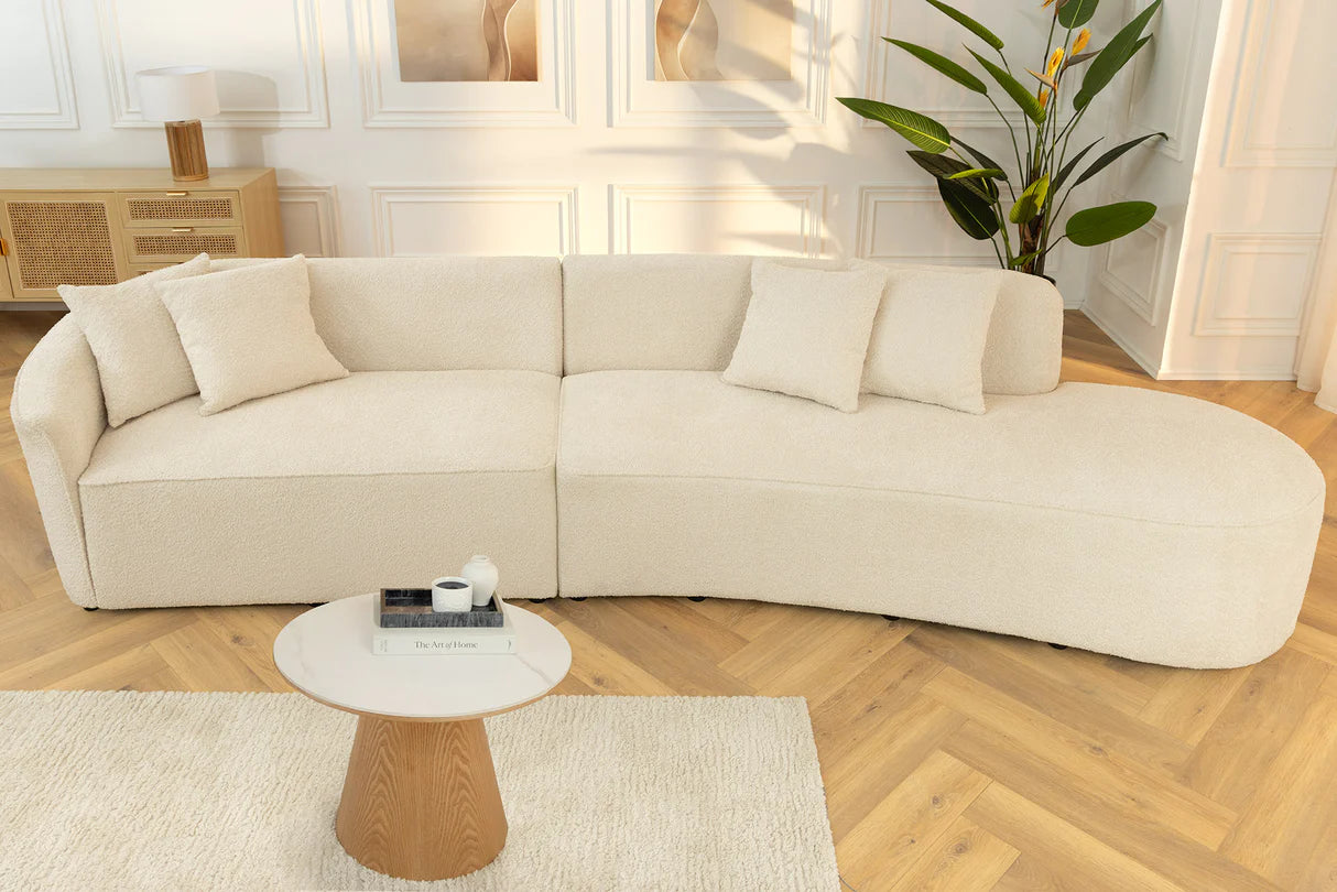 Beżowa sofa z tkaniny bouclé o opływowym kształcie – nowoczesny mebel wypoczynkowy do eleganckiego salonu