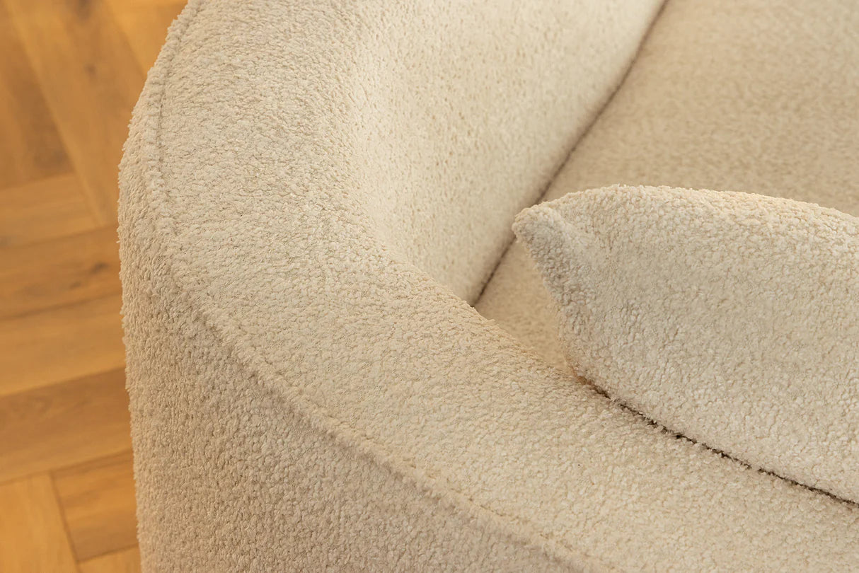 Beżowa sofa z tkaniny bouclé o opływowym kształcie – nowoczesny mebel wypoczynkowy do eleganckiego salonu