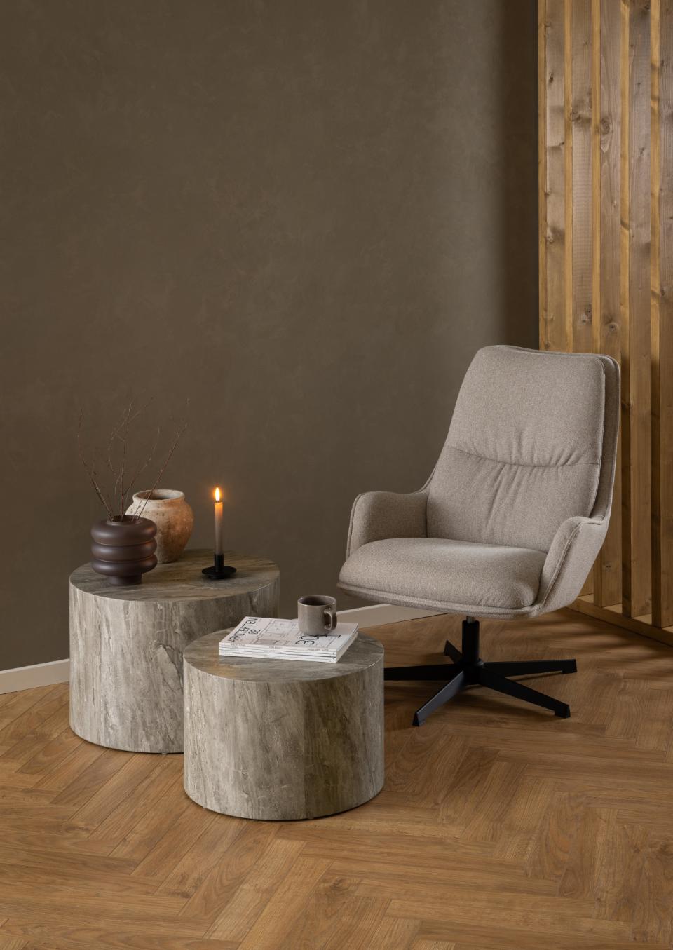 Okrągłe stoliki kawowe Dice grey marble River ustawione przy tapicerowanym fotelu