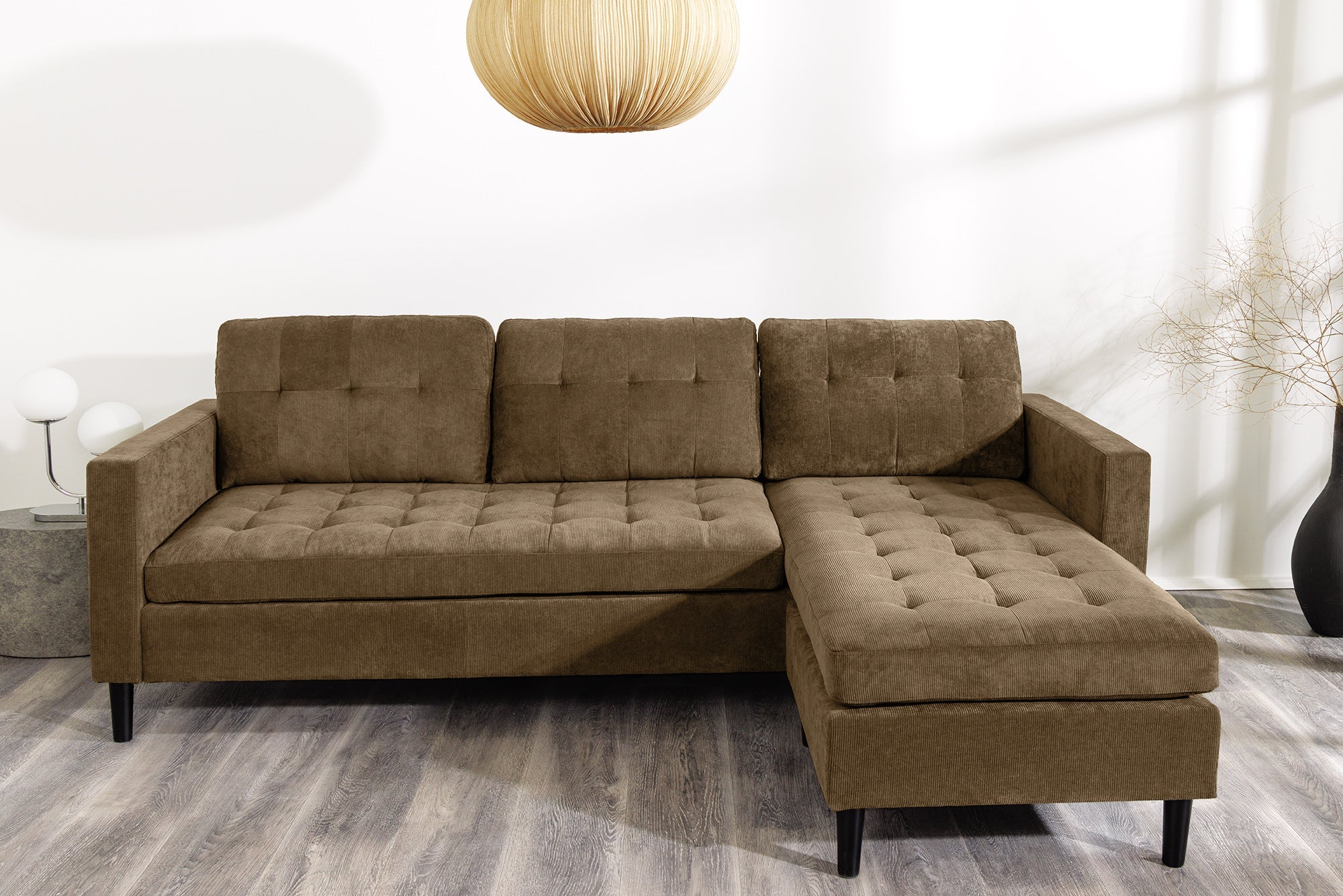 Nowoczesna sofa narożna w tkaninie cord, z otomaną lewą/prawą, tył tapicerowany, filcowe podkładki pod nogi