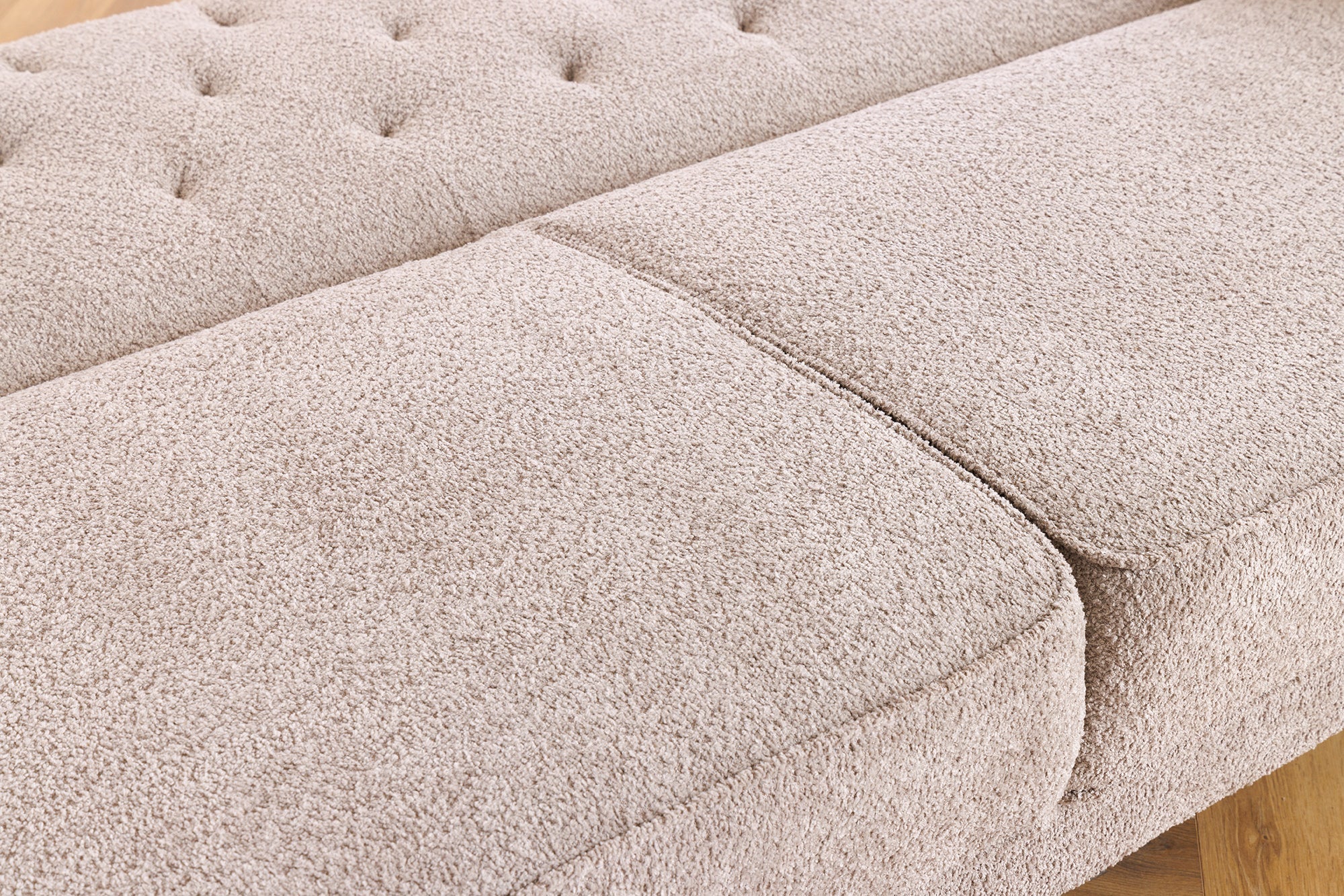 Trzyosobowa sofa w stylu klasycznym z tkaniny boucle, z pikowaniem, drewnianymi nogami i funkcją spania.