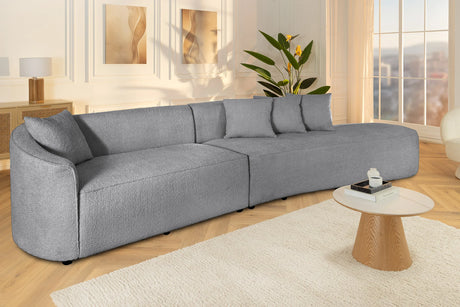 Beżowa sofa z tkaniny boucle o opływowym kształcie – nowoczesny mebel wypoczynkowy do eleganckiego salonu