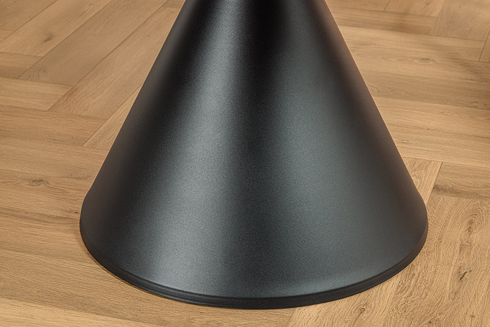 Okrągły stół z białym ceramicznym blatem imitującym marmur i czarną stożkową podstawą z metalu.