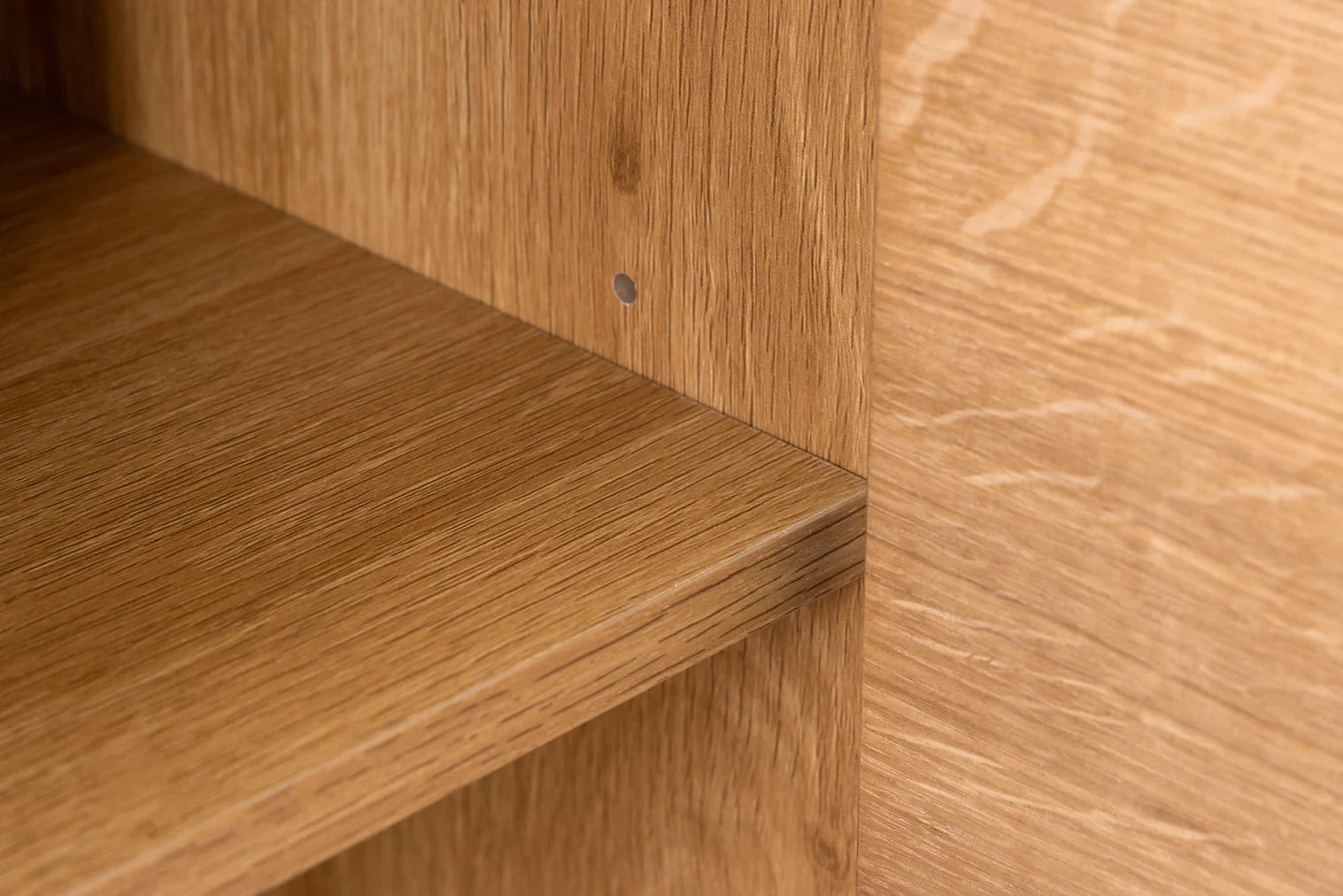 Nowoczesna owalna komoda z płyty MDF w naturalnym fornirze dębowym, z ryflowanymi frontami, czarnymi metalowymi nogami i drzwiami na magnes bez uchwytów – do salonu, jadalni lub biura.