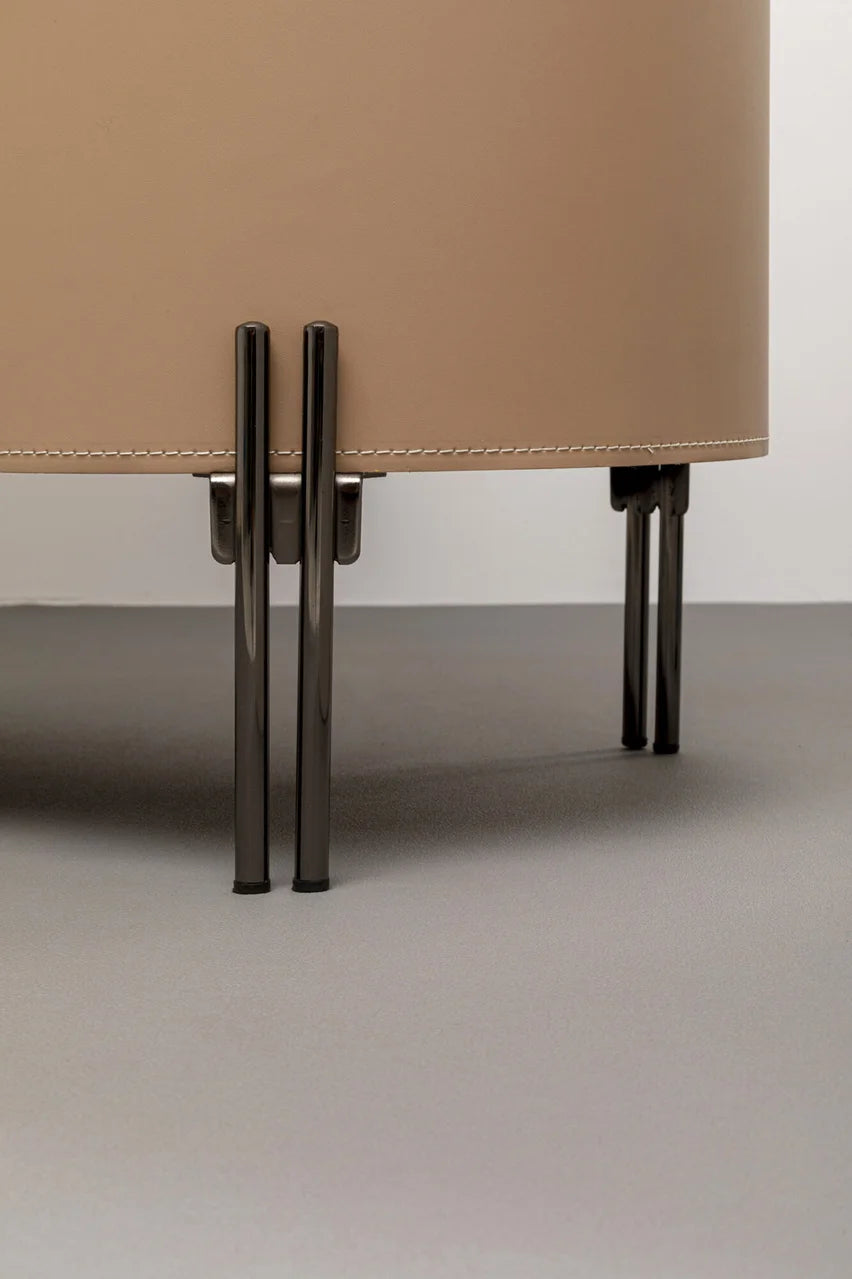 Beżowa komoda w ekoskórze na czarnych, stalowych nogach z zaoblonymi bokami i półkami w środku