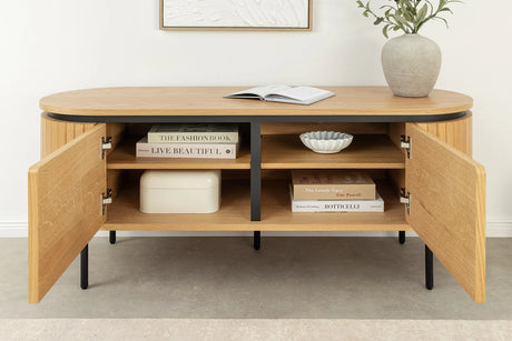 Nowoczesna szafka RTV z płyty MDF pokrytej naturalnym fornirem dębowym, z ryflowanymi bokami, zaokrąglonymi krawędziami, czarnymi metalowymi nóżkami i drzwiami otwieranymi na magnes.