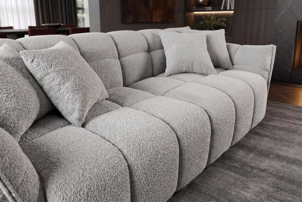 Szara sofa CLOUD w tkaninie bouclé o miękkiej zaokrąglonej formie do nowoczesnego salonu
