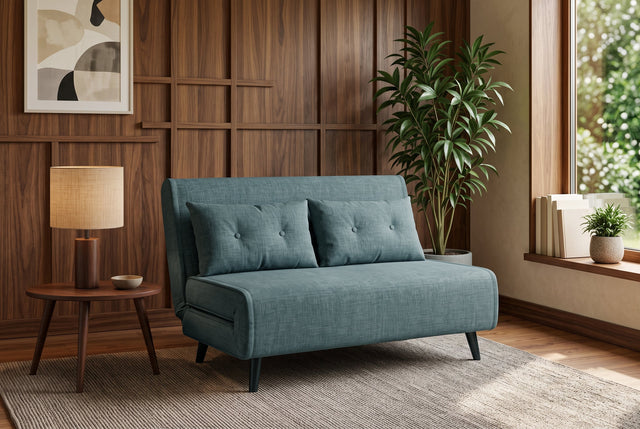 Niebieska sofa z funkcją spania 140 cm w tkaninie aksamit z drewnianymi nóżkami i poduszkami