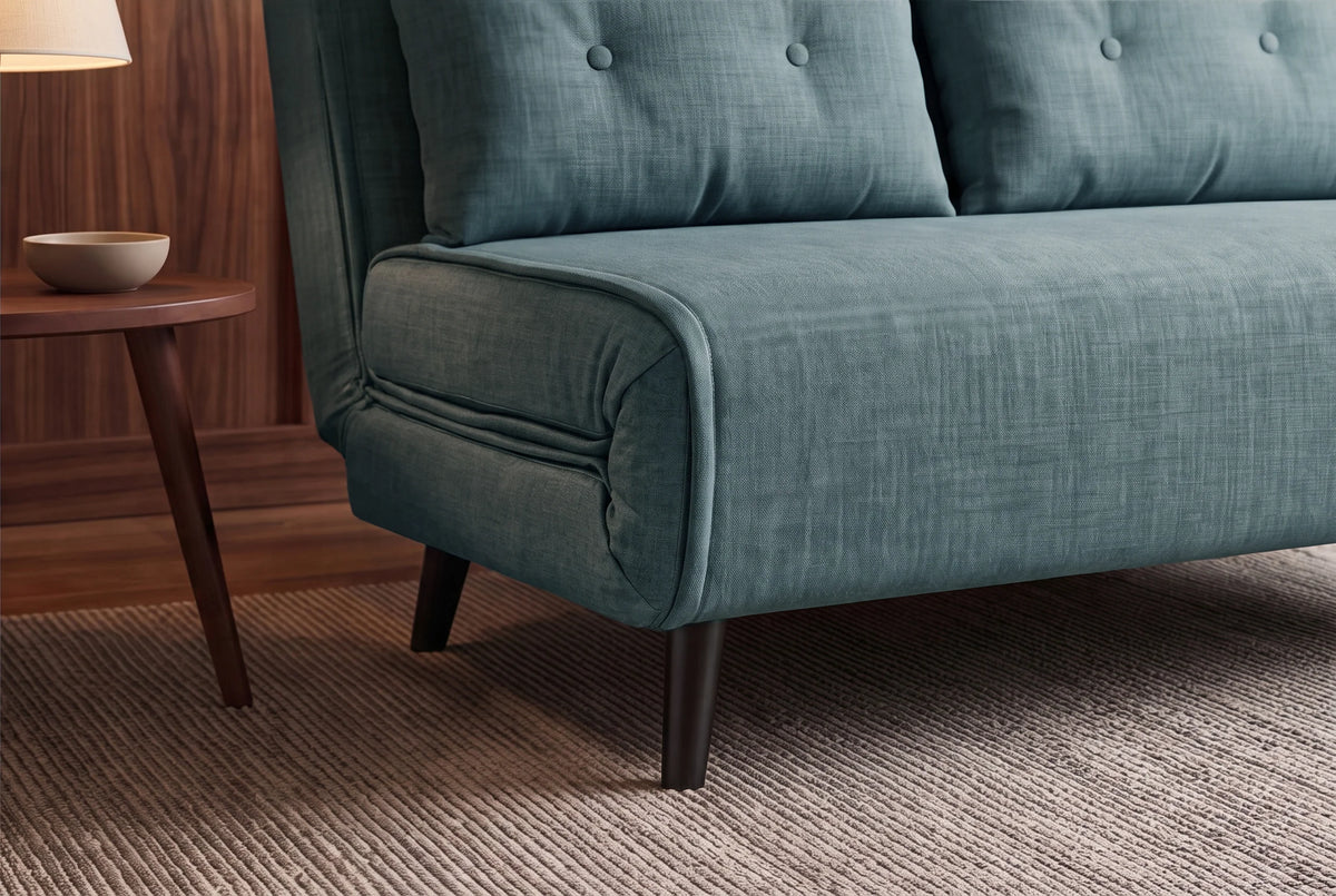 Niebieska sofa z funkcją spania 140 cm w tkaninie aksamit z drewnianymi nóżkami i poduszkami