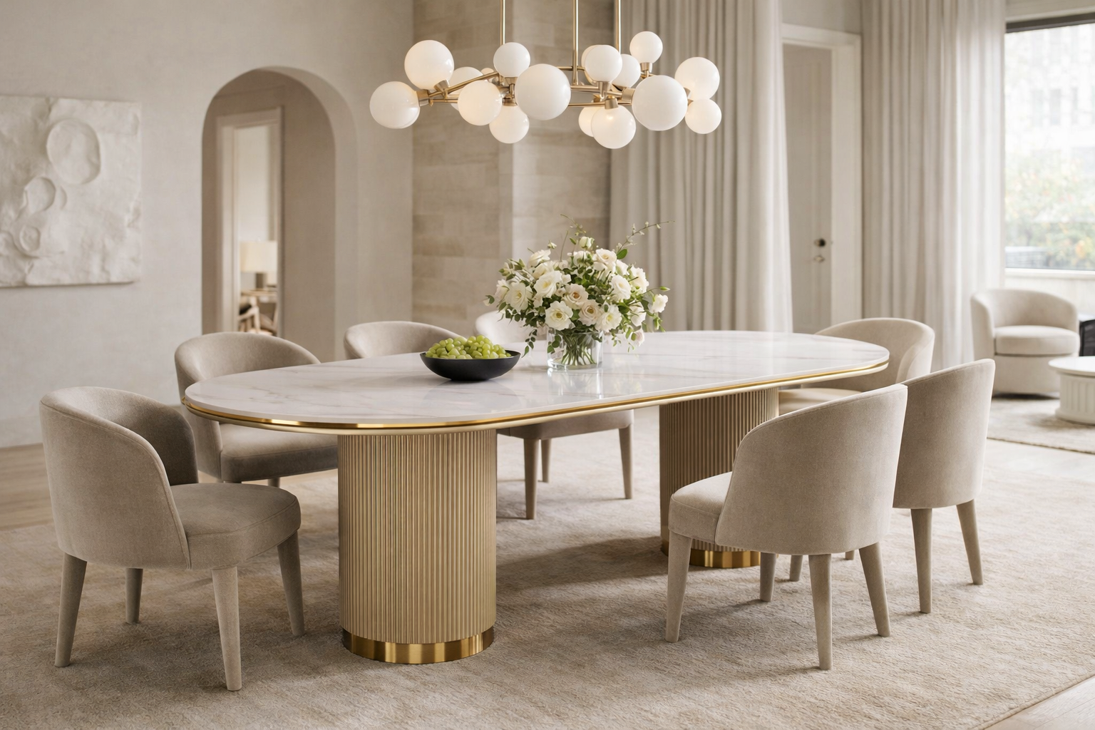 Nowoczesny stół w kolorze złota z białym owalnym blatem syntetycznym, na dwóch ryflowanych cylindrycznych nogach ze złotym wykończeniem.