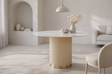 Nowoczesny stół w kolorze złota z białym owalnym blatem syntetycznym, na  ryflowanej podstawie ze złotym wykończeniem.