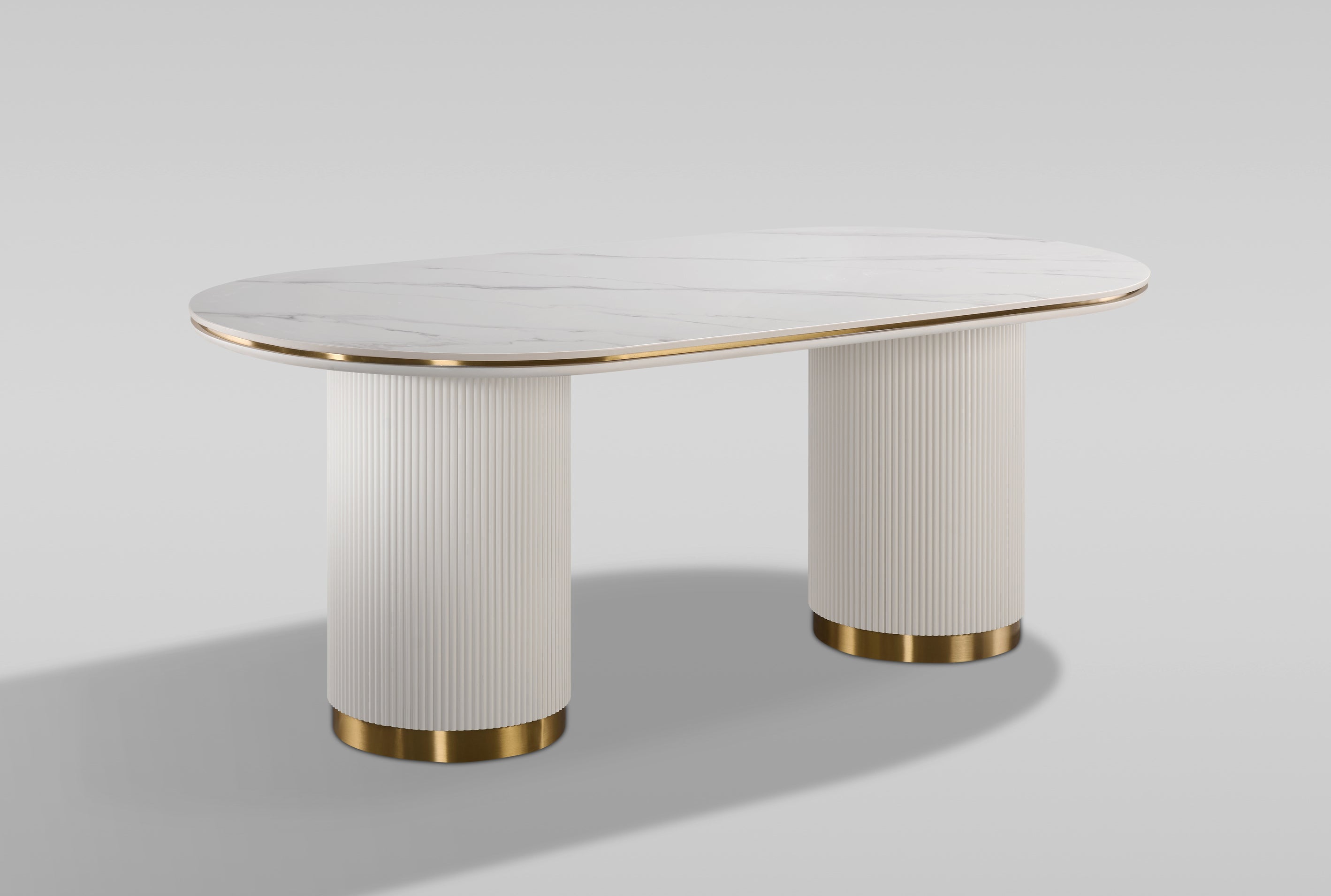 Nowoczesny stół w kolorze białym, owalnym blatem syntetycznym, na dwóch ryflowanych cylindrycznych nogach ze złotym wykończeniem.