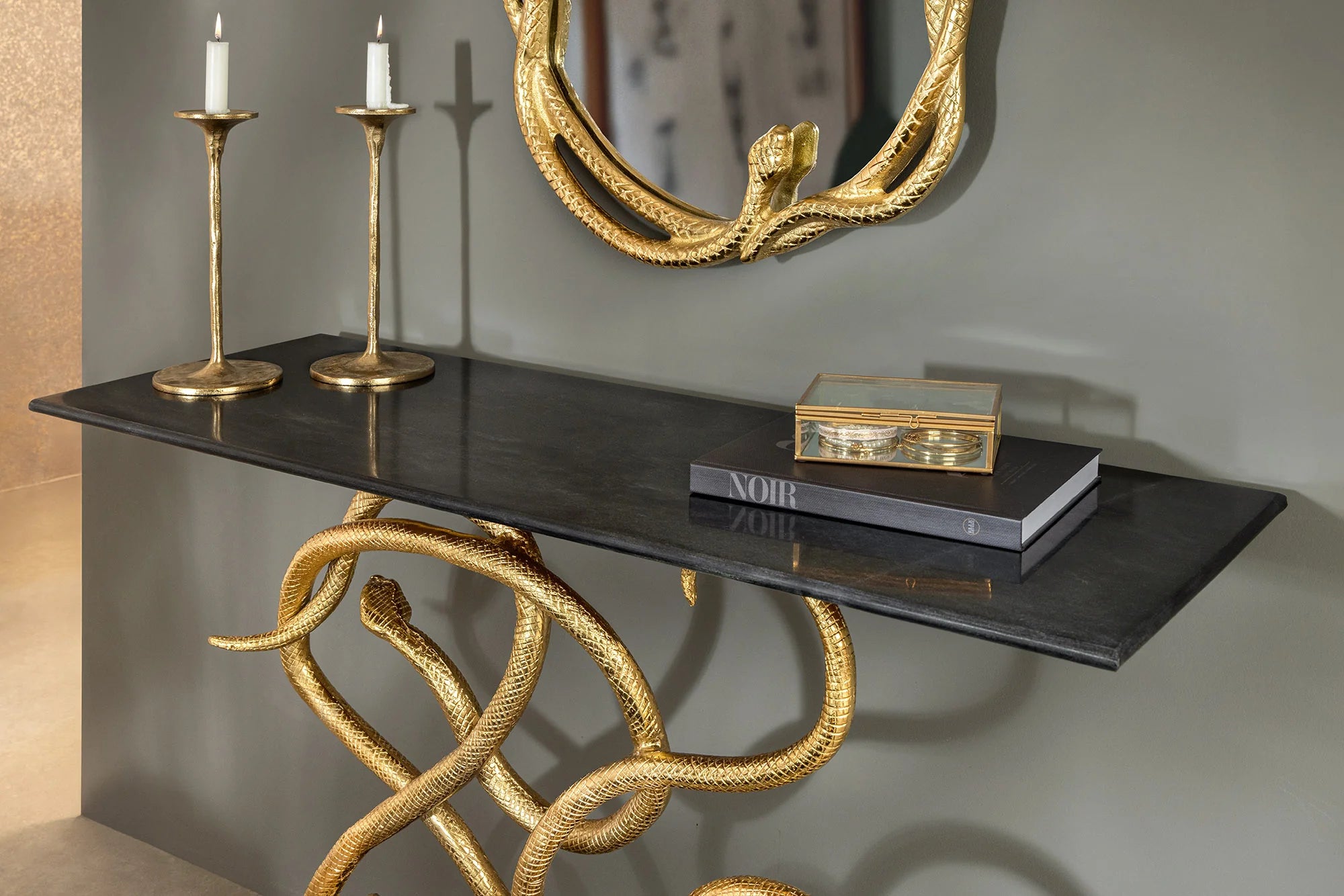 Konsola czarny marmur ze złotym stelażem w kształcie węża, luksusowy design glamour.