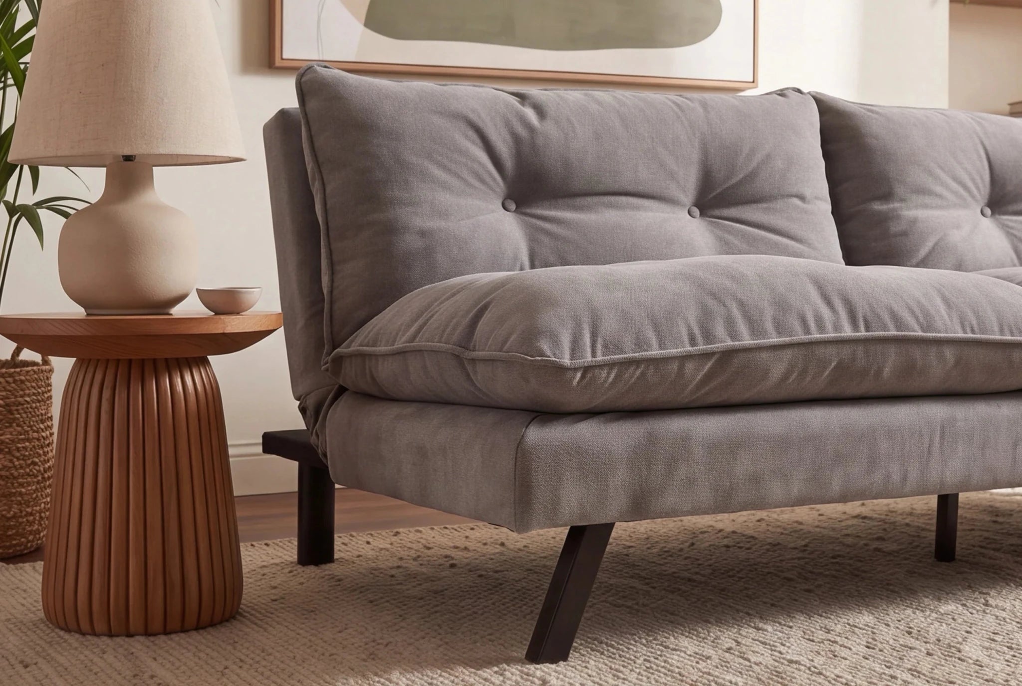 Jasno szara sofa rozkładana z tapicerką szenilową i czarnymi nogami z drewna eukaliptusowego