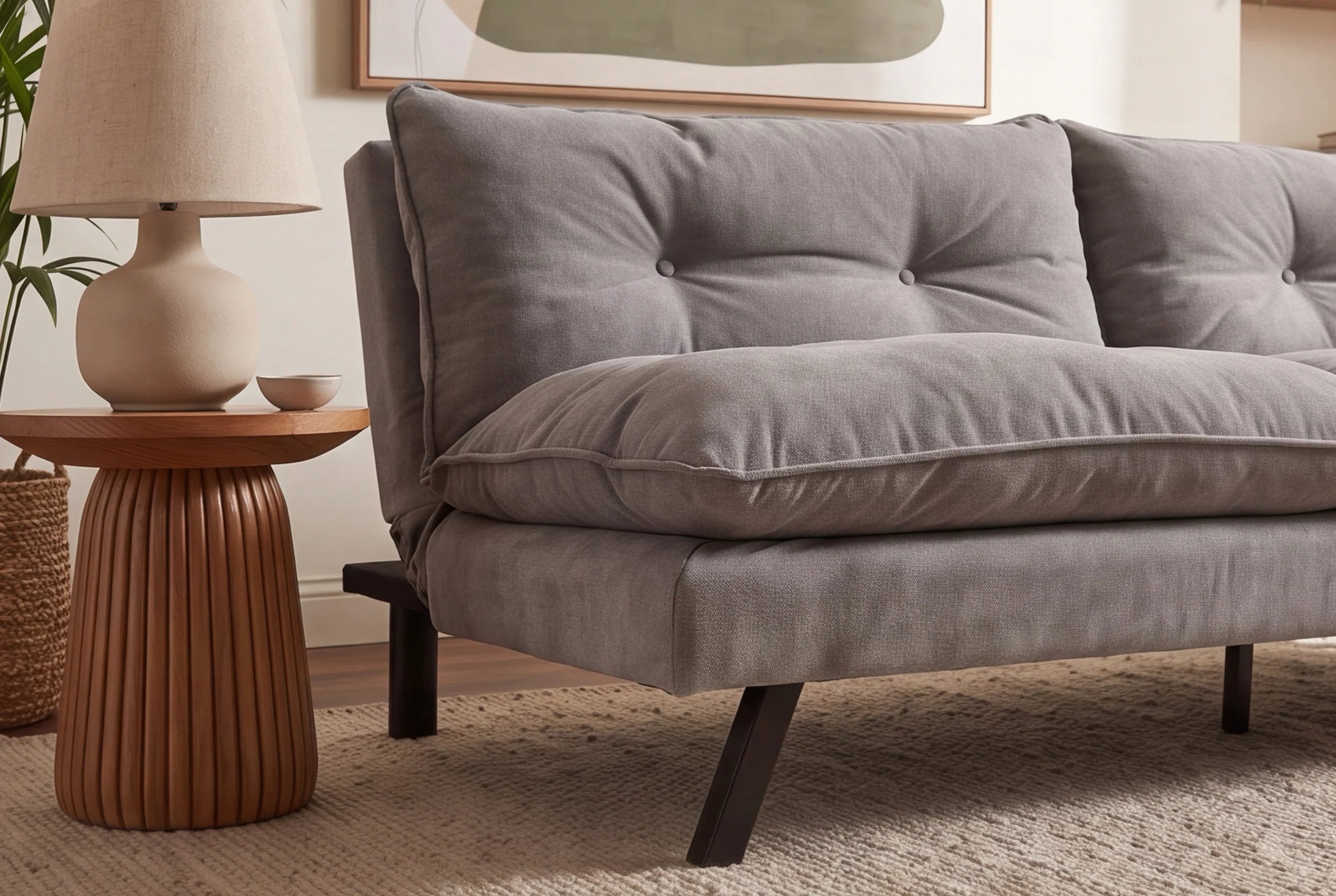 Jasno szara sofa rozkładana z tapicerką szenilową i czarnymi nogami z drewna eukaliptusowego