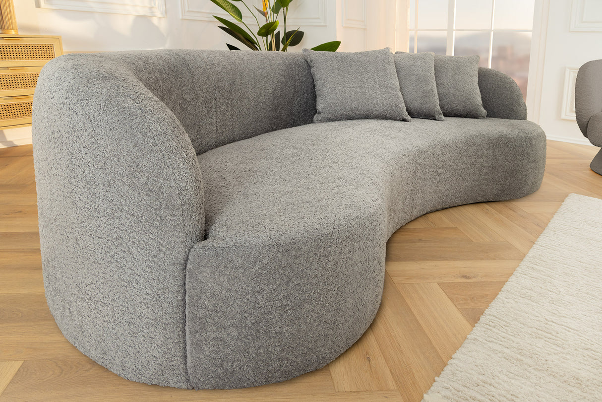 Szara sofa z tkaniny bouclé o opływowym kształcie – nowoczesny mebel wypoczynkowy do eleganckiego salonu