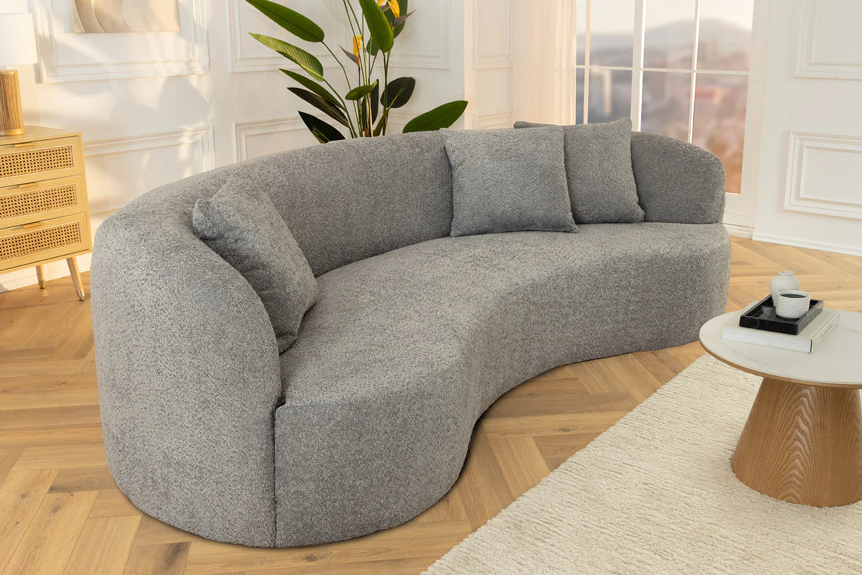 Szara sofa z tkaniny bouclé o opływowym kształcie – nowoczesny mebel wypoczynkowy do eleganckiego salonu