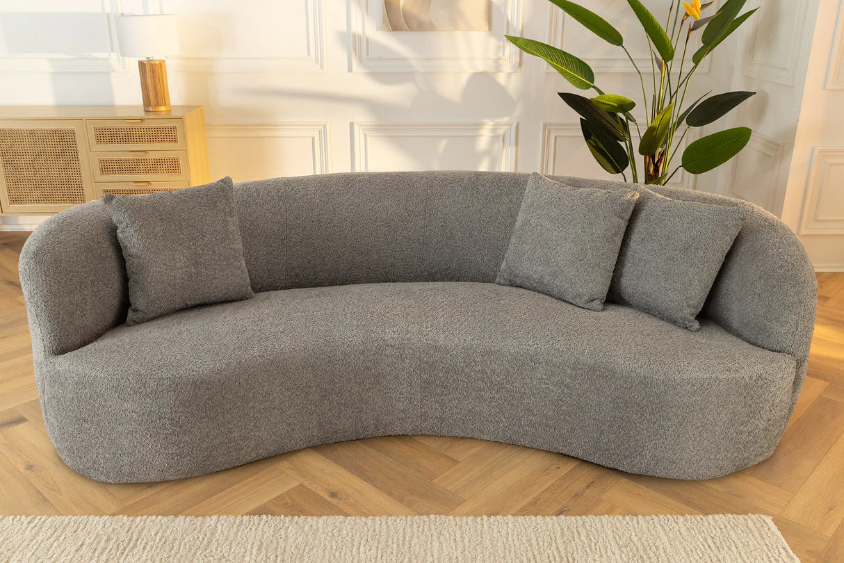 Szara sofa z tkaniny bouclé o opływowym kształcie – nowoczesny mebel wypoczynkowy do eleganckiego salonu