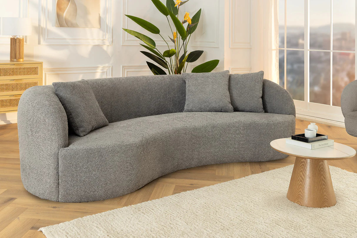 Szara sofa z tkaniny bouclé o opływowym kształcie – nowoczesny mebel wypoczynkowy do eleganckiego salonu